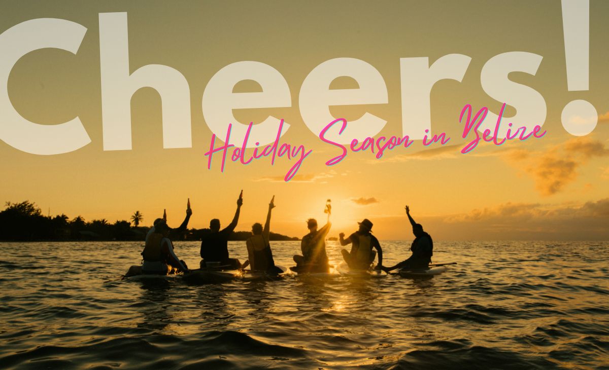 Group of adventure travelers sitting on paddle-boards cheering to the sunset at sea in Belize