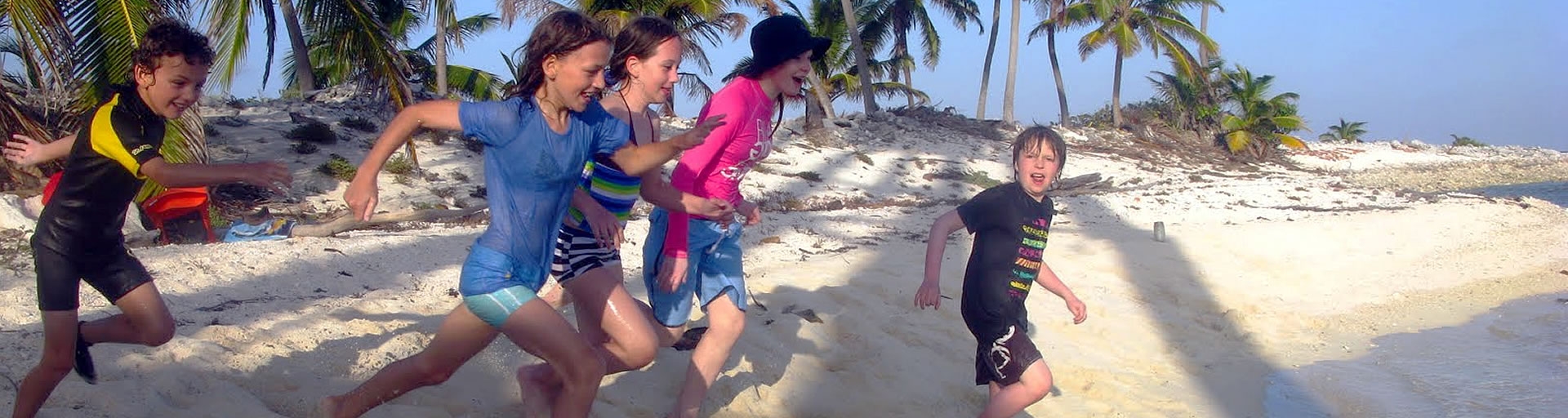 children running to the ocean in belize