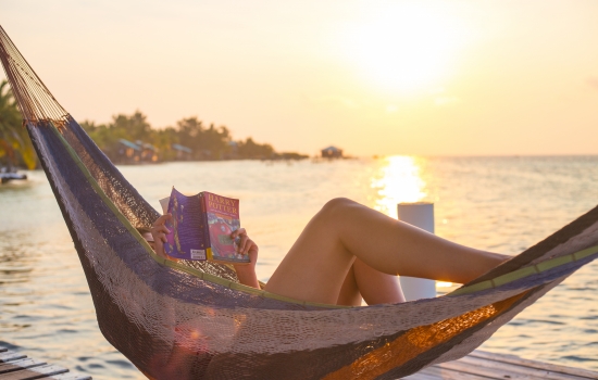 Reading a book in Belize in a hammock