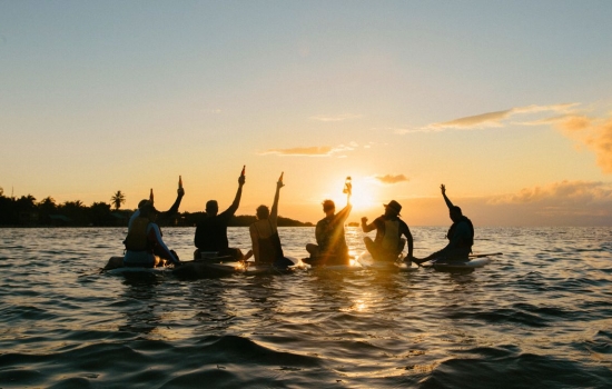 group cheer paddle board during sunset