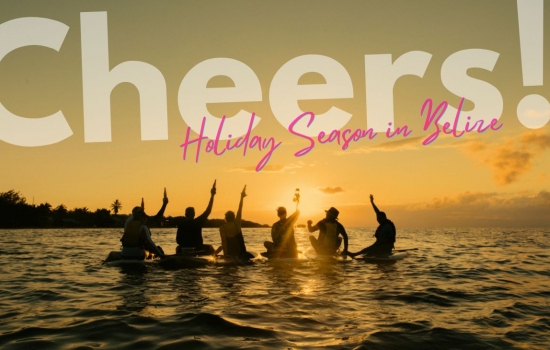 Group of adventure travelers sitting on paddle-boards cheering to the sunset at sea in Belize